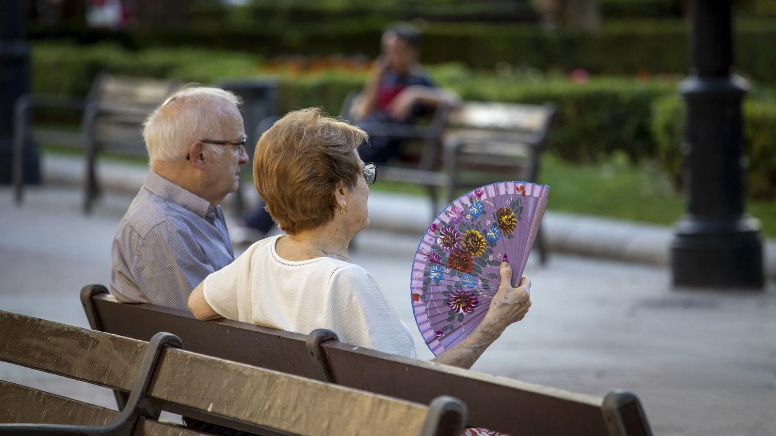 Dos persones majors, assentades en un banc este divendres