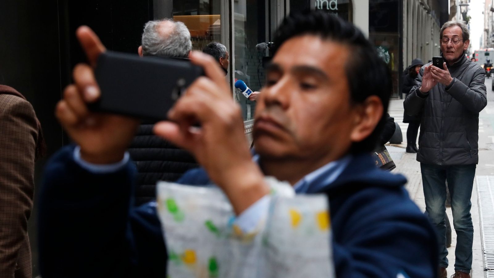 Vianants observen i fotografien les cases de canvi als carrers de Buenos Aires