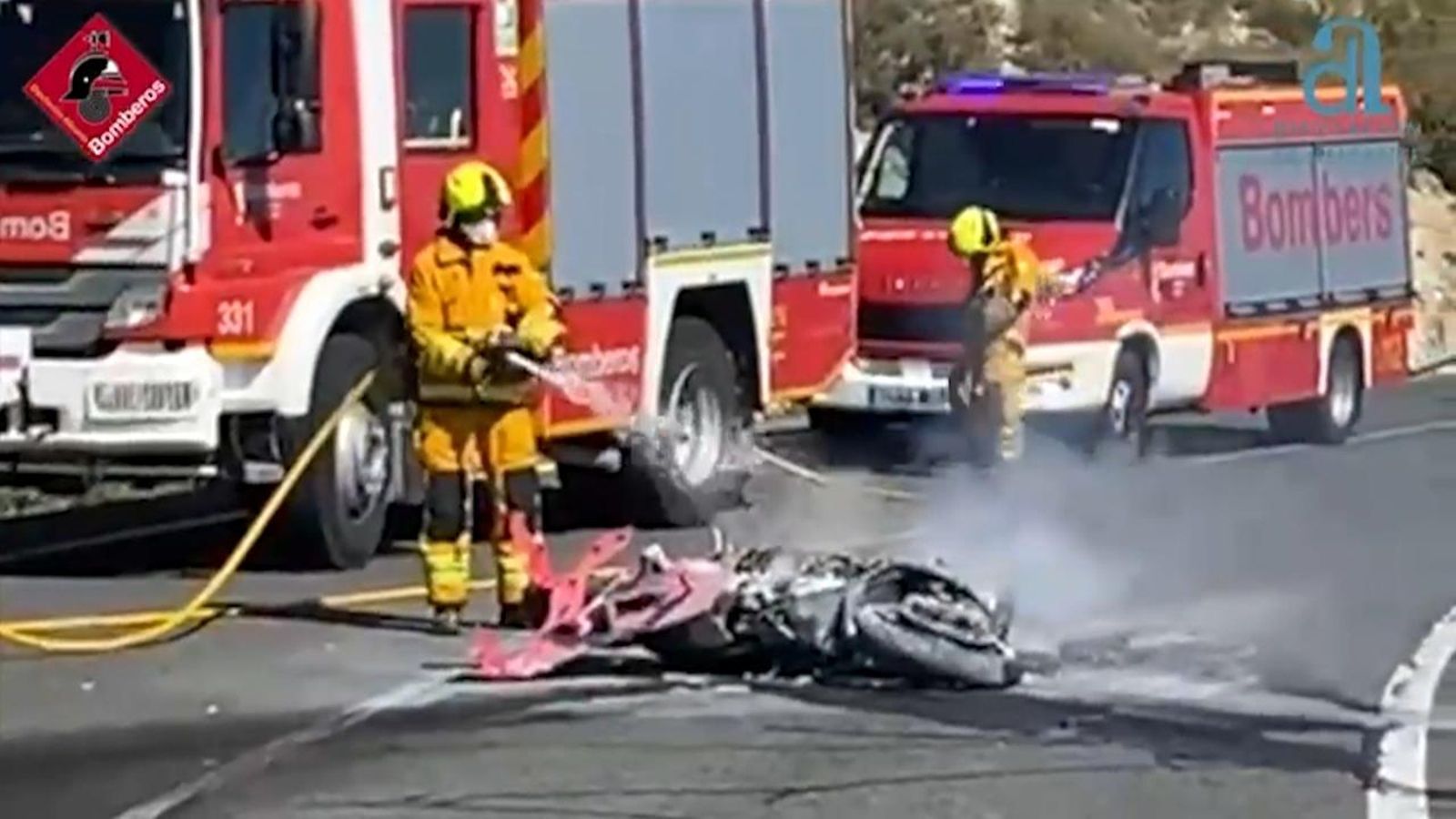 Els bombers treballen per apagar les flames de la moto accidentada a Benimassot