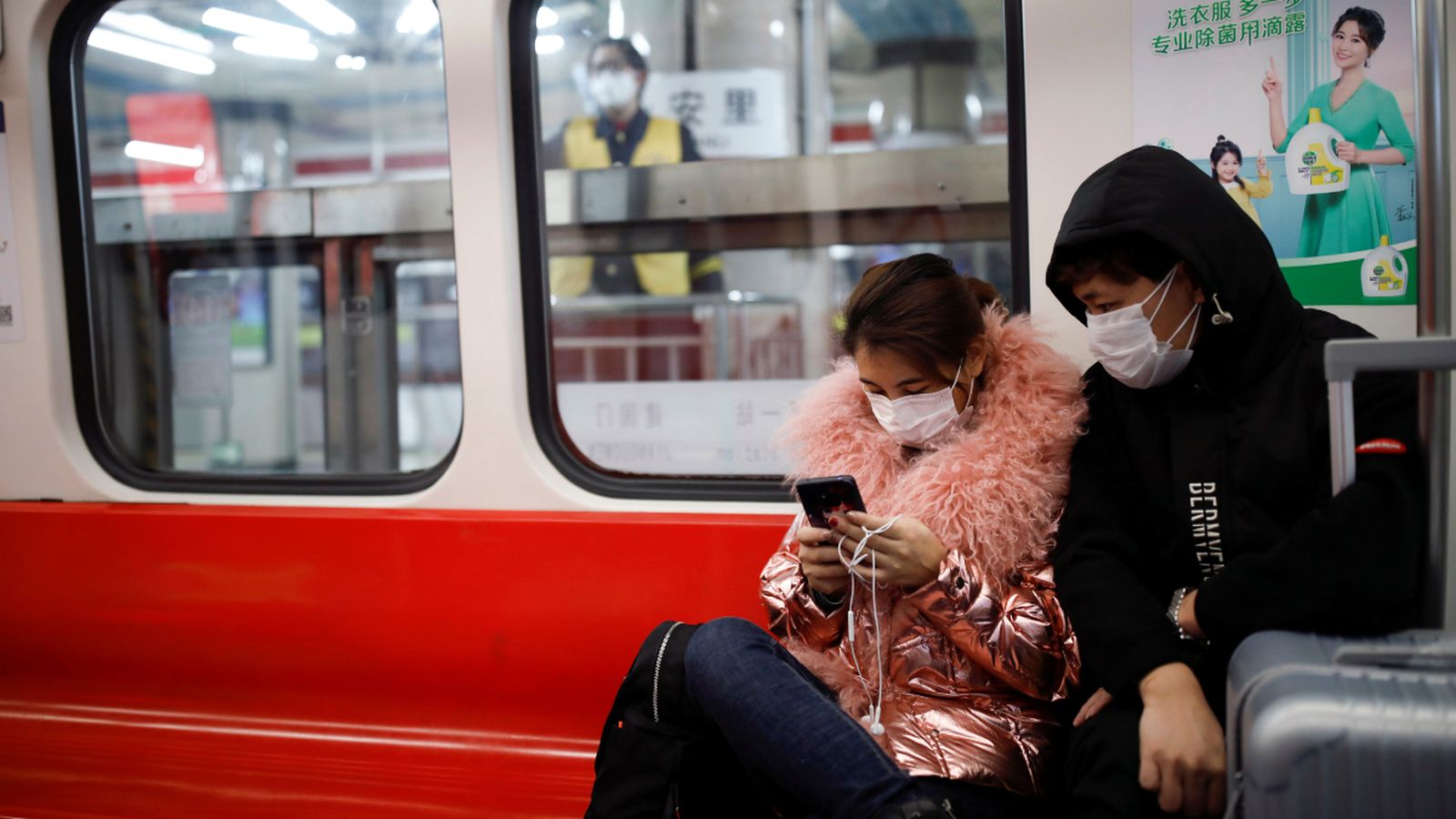 Dos joves amb màscares viatgen en el metro de Pequín