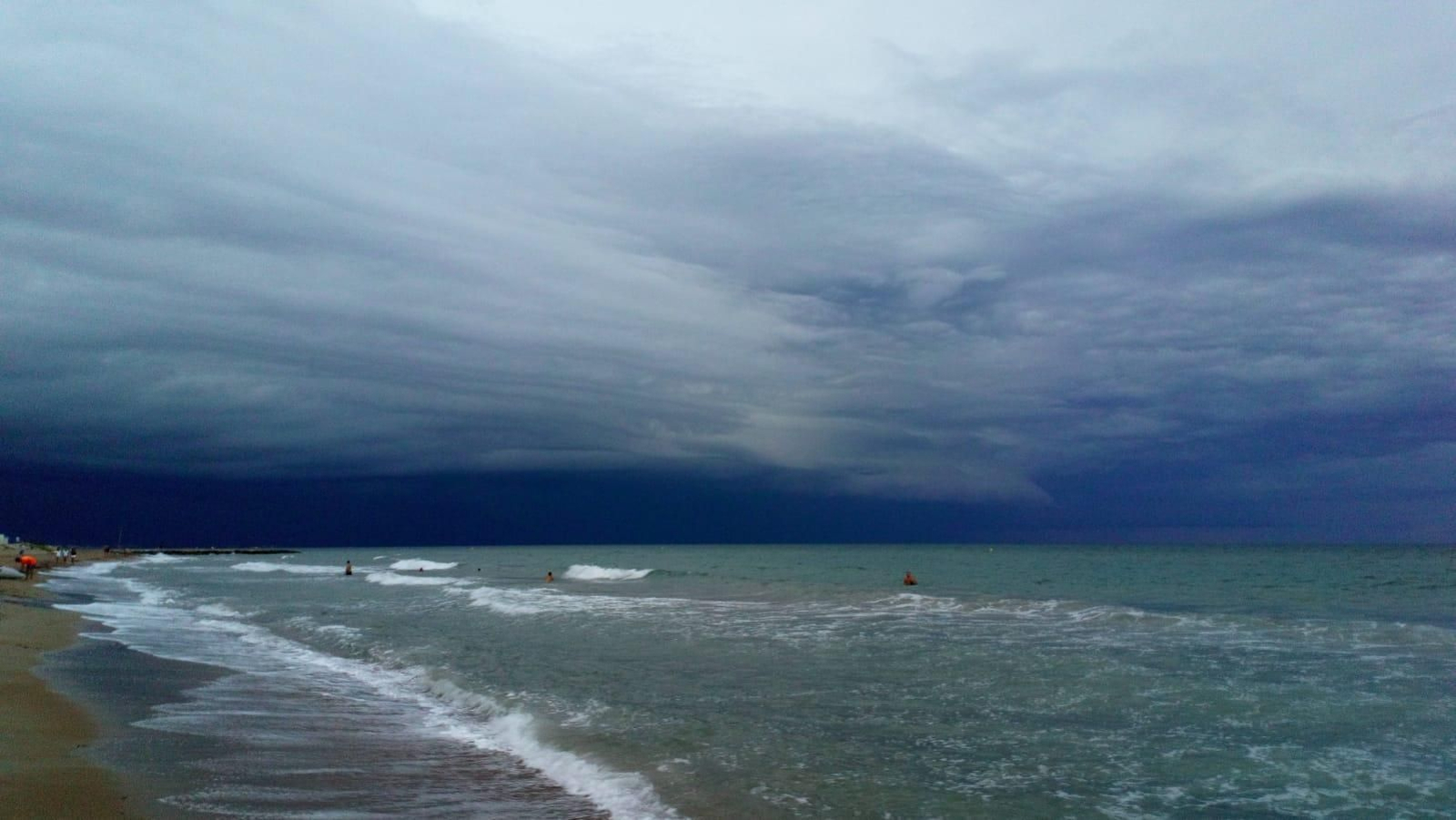 Gent banyant-se a la mar a Dénia mentre s'apropava una tempesta el 26 d'agost