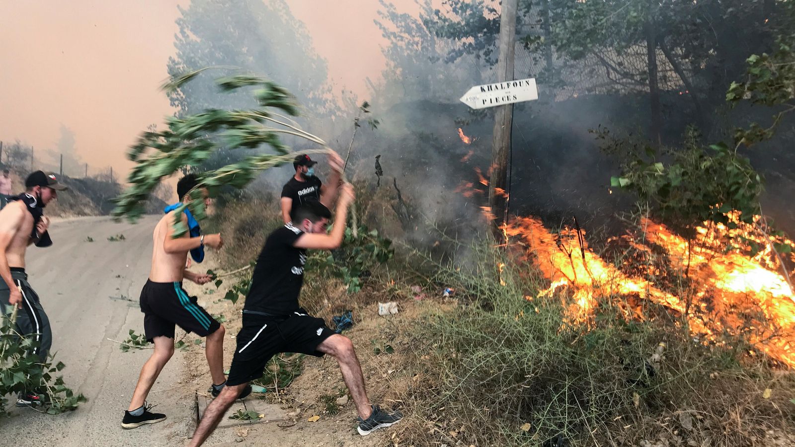 Residents de la població d'Achallam intenten sufocar les flames amb matolls i branques