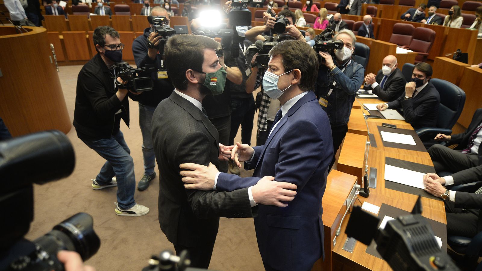 El president en funcions de la Junta de Castella i Lleó, a la dreta, saluda al que serà el seu vicepresident, de Vox, a l’esquerra en arribar al debat d'investidura