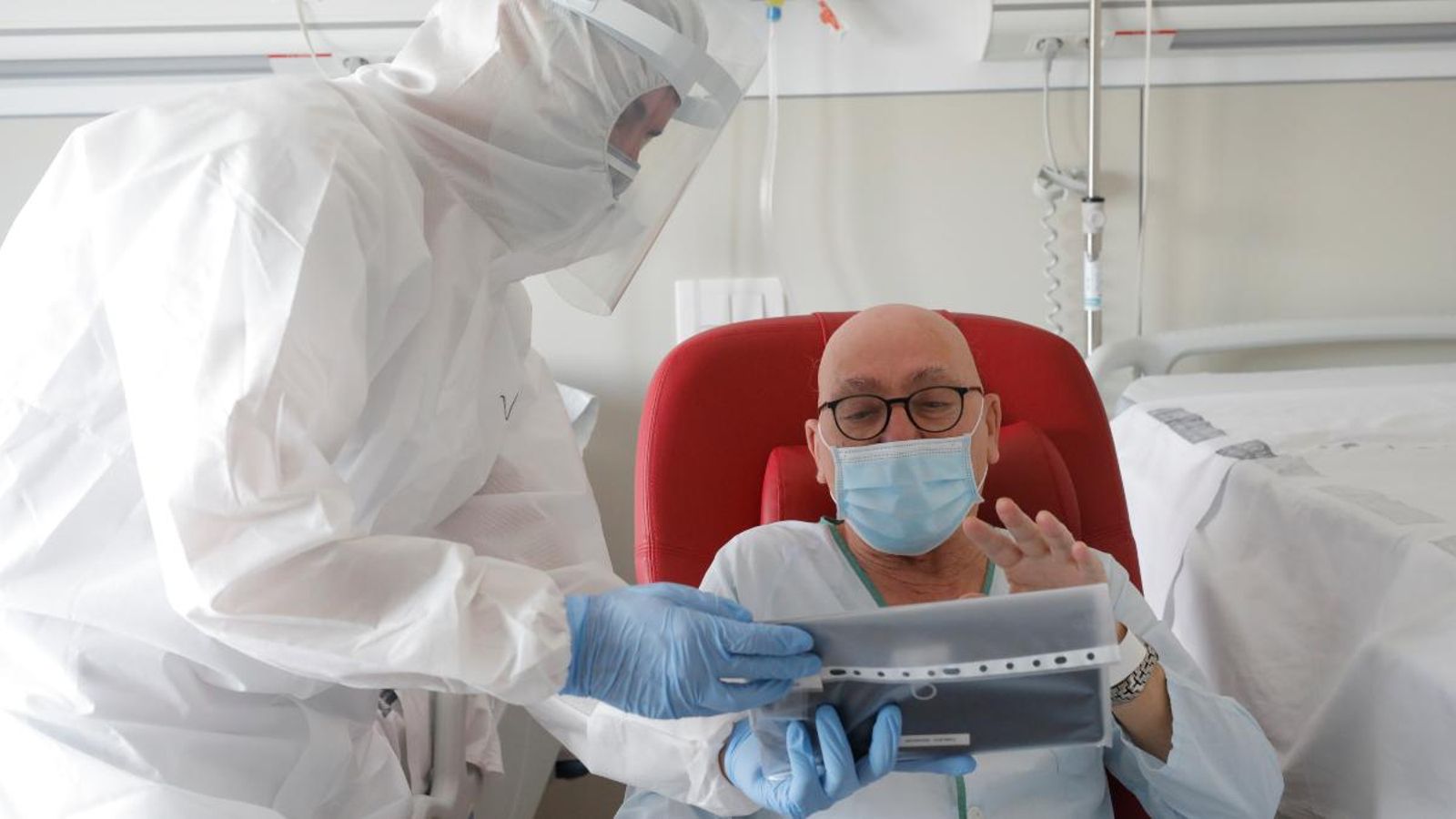 Un sanitari ajuda a fer una videoconferència a un pacient, negatiu de Covid-19, en l’Hospital Arnau de Vilanova de València