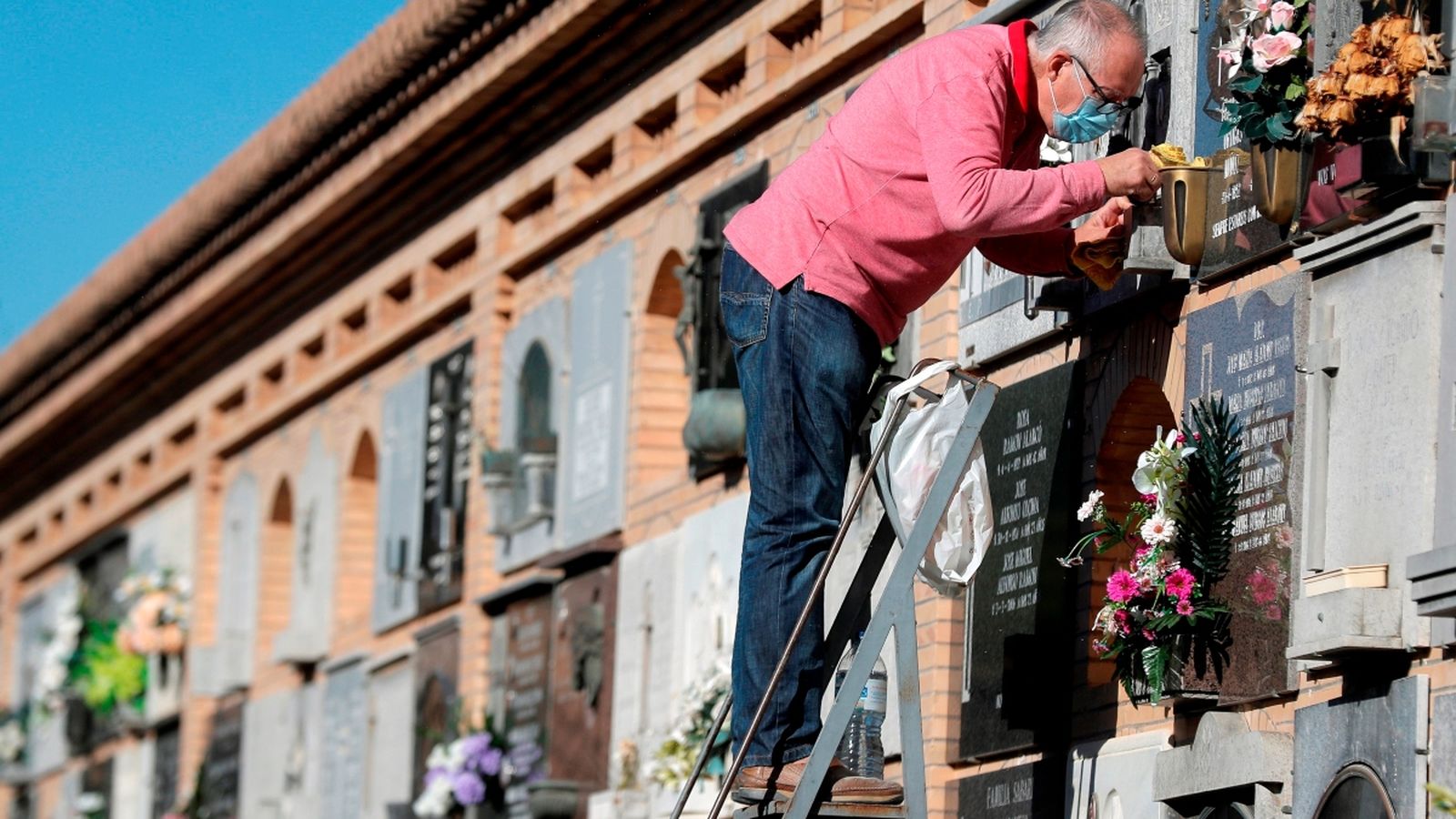Un home neteja una làpida al Cementeri General de València