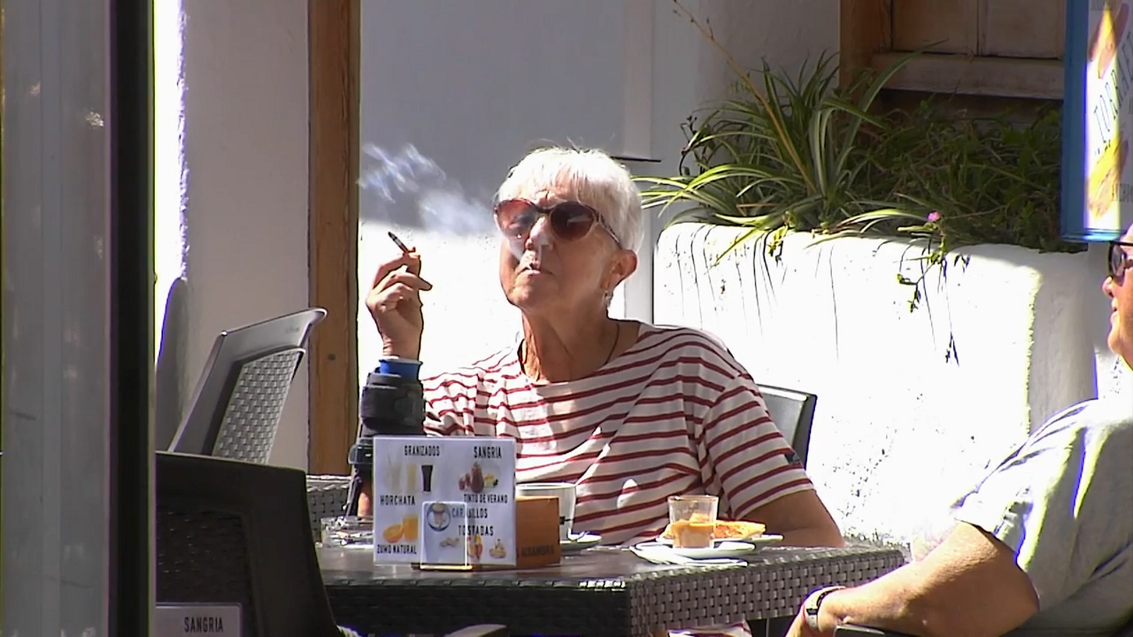 Una dona fumant en una terrassa en una imatge d'arxiu