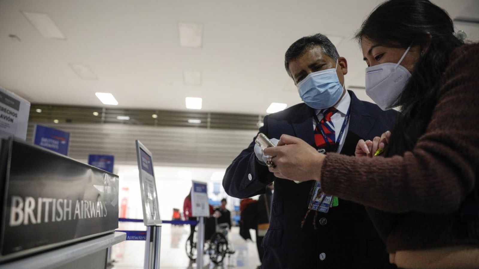 Un treballador de British Airways atén una passatgera