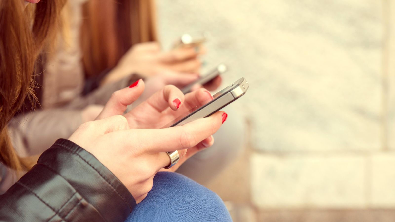 Un grup d'adolescents consulten els seus telèfons mòbils