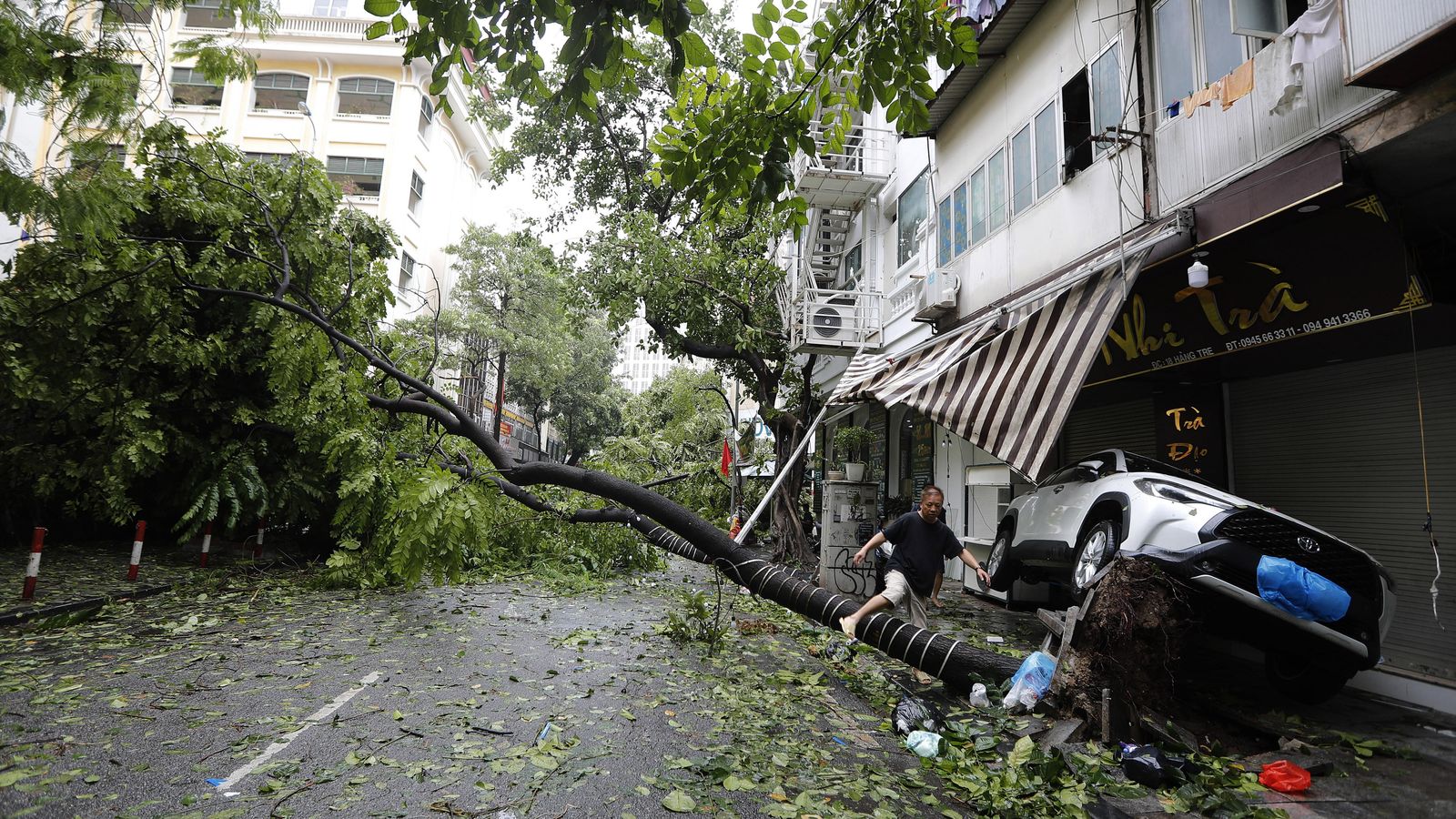 Un home salta un arbre caigut pel tifó Yagi a Hanoi, Vietnam