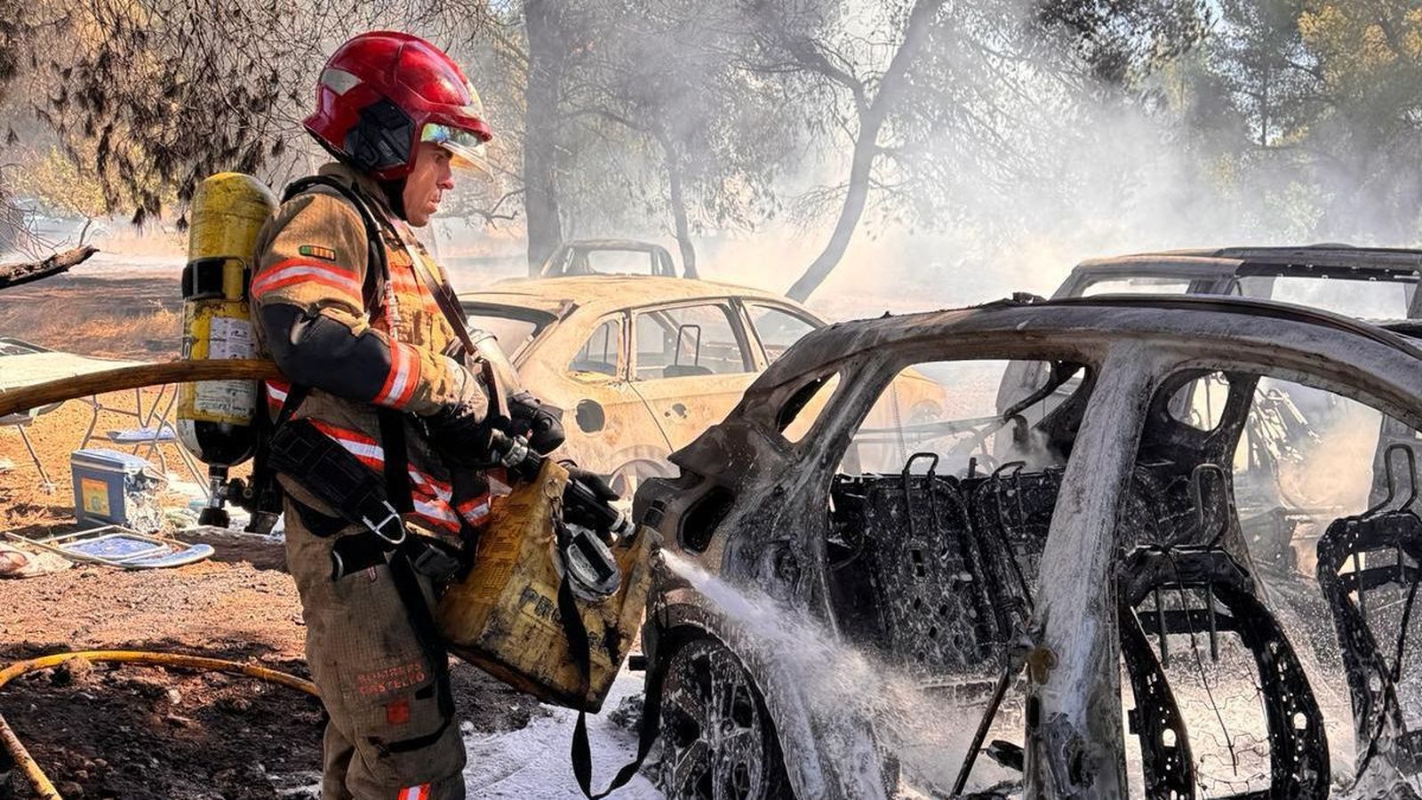 Els bombers apaguen els vehicles incendiats