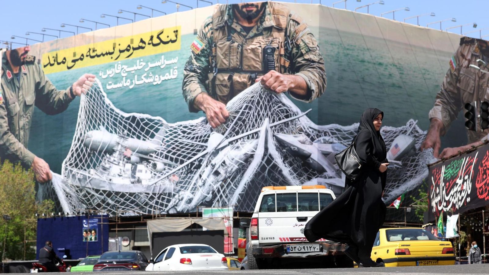 Una dona passa per davant d'un cartell de Teheran, amb el missatge 'L'estret d'Ormuz estarà tancat'