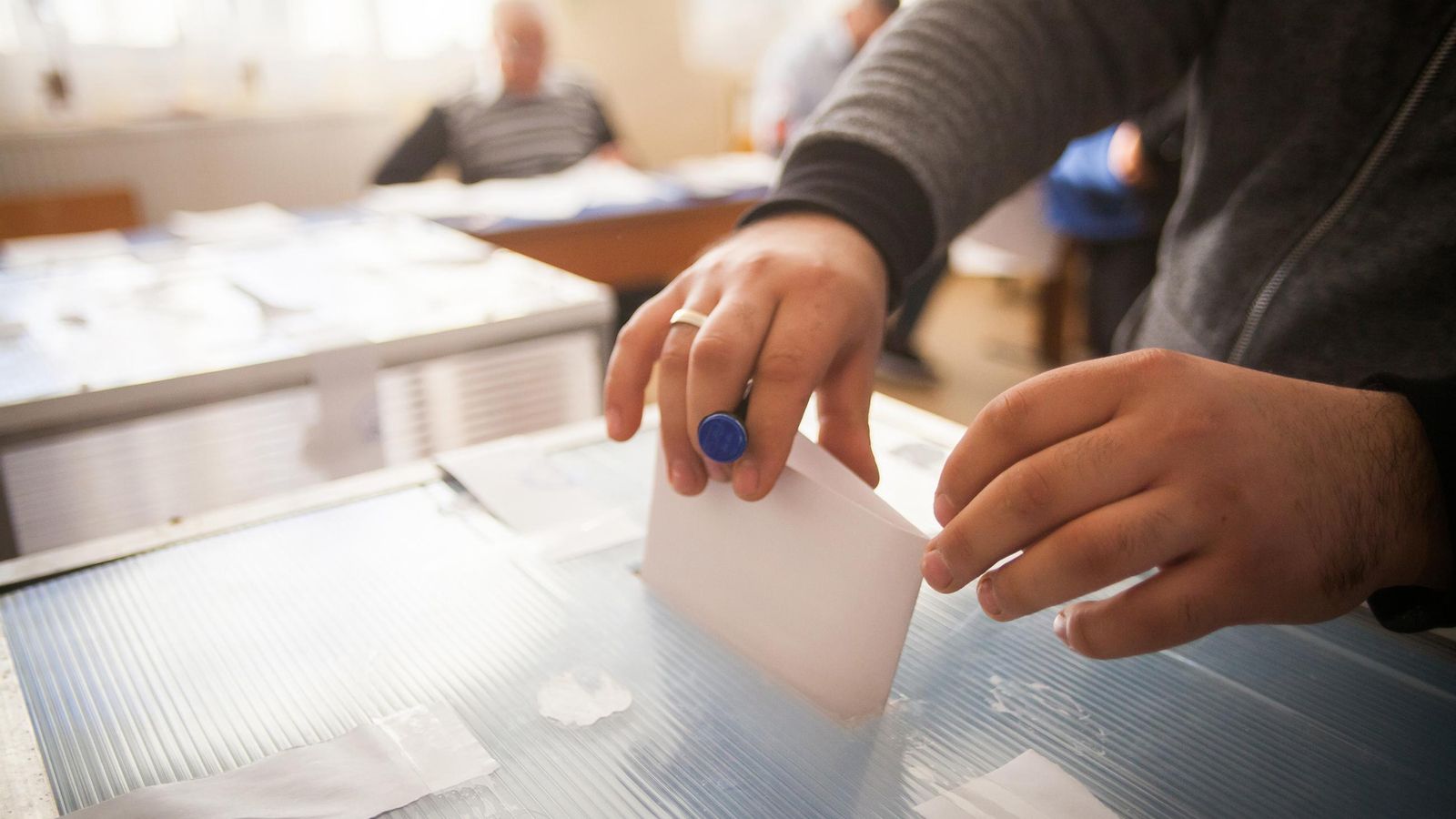 Una persona deposita el vot en una urna, en una imatge d'arxiu Una persona deposita el vot en una urna, en una imatge d'arxiu