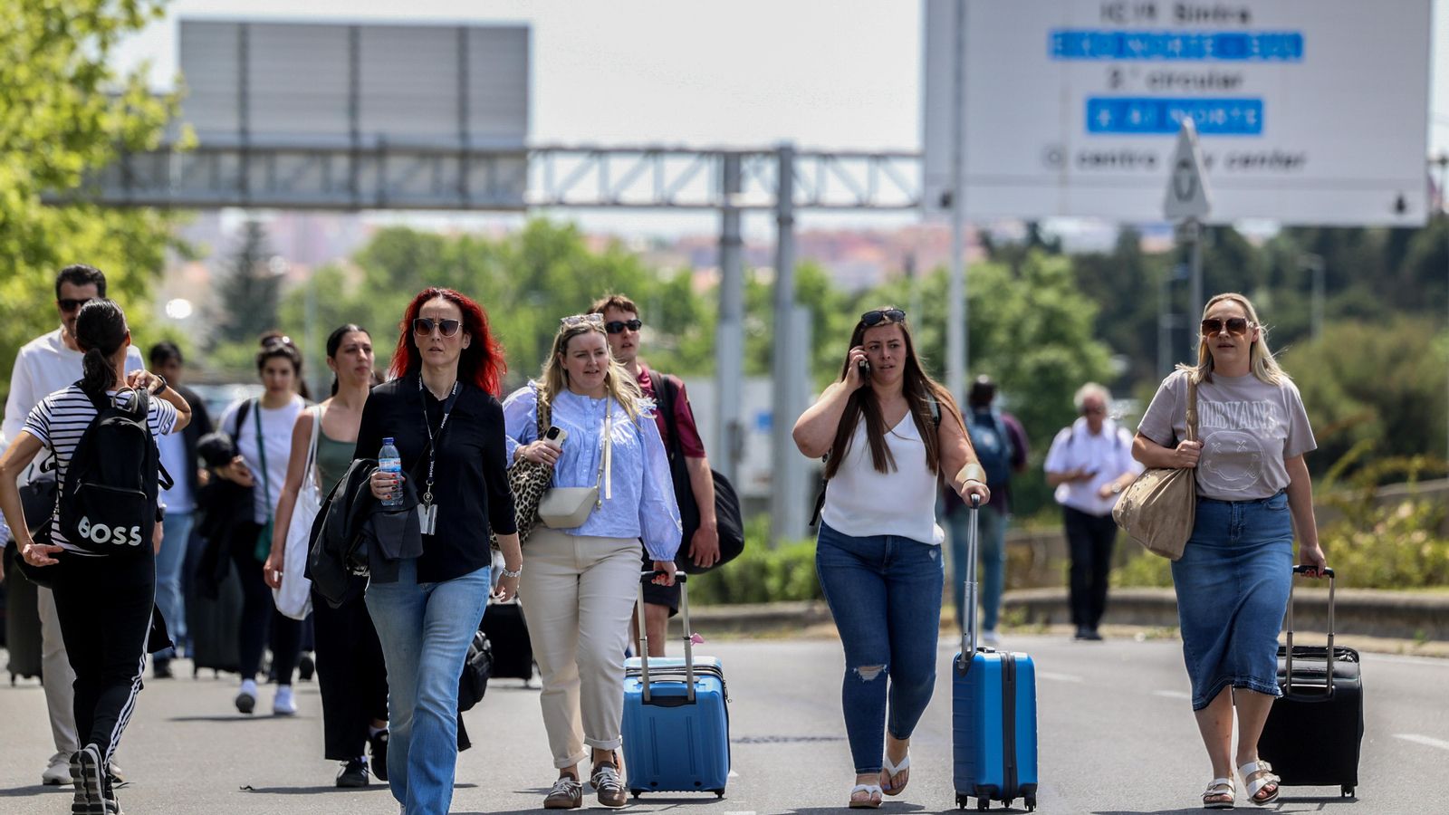 Els passatgers caminen cap a la zona d'eixides de l'aeroport Humberto Delgado de Lisboa, ja que la zona està tancada a causa de l'apagada