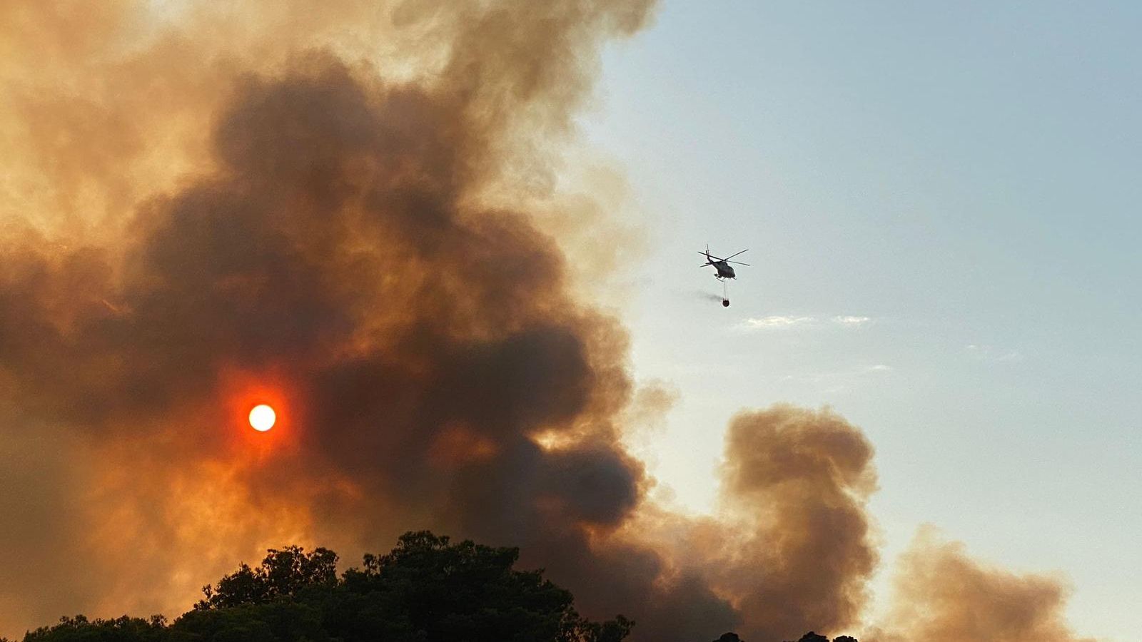 Un helicòpter de bombers treballa en l'extinció de l'incendi forestal de Benicàssim