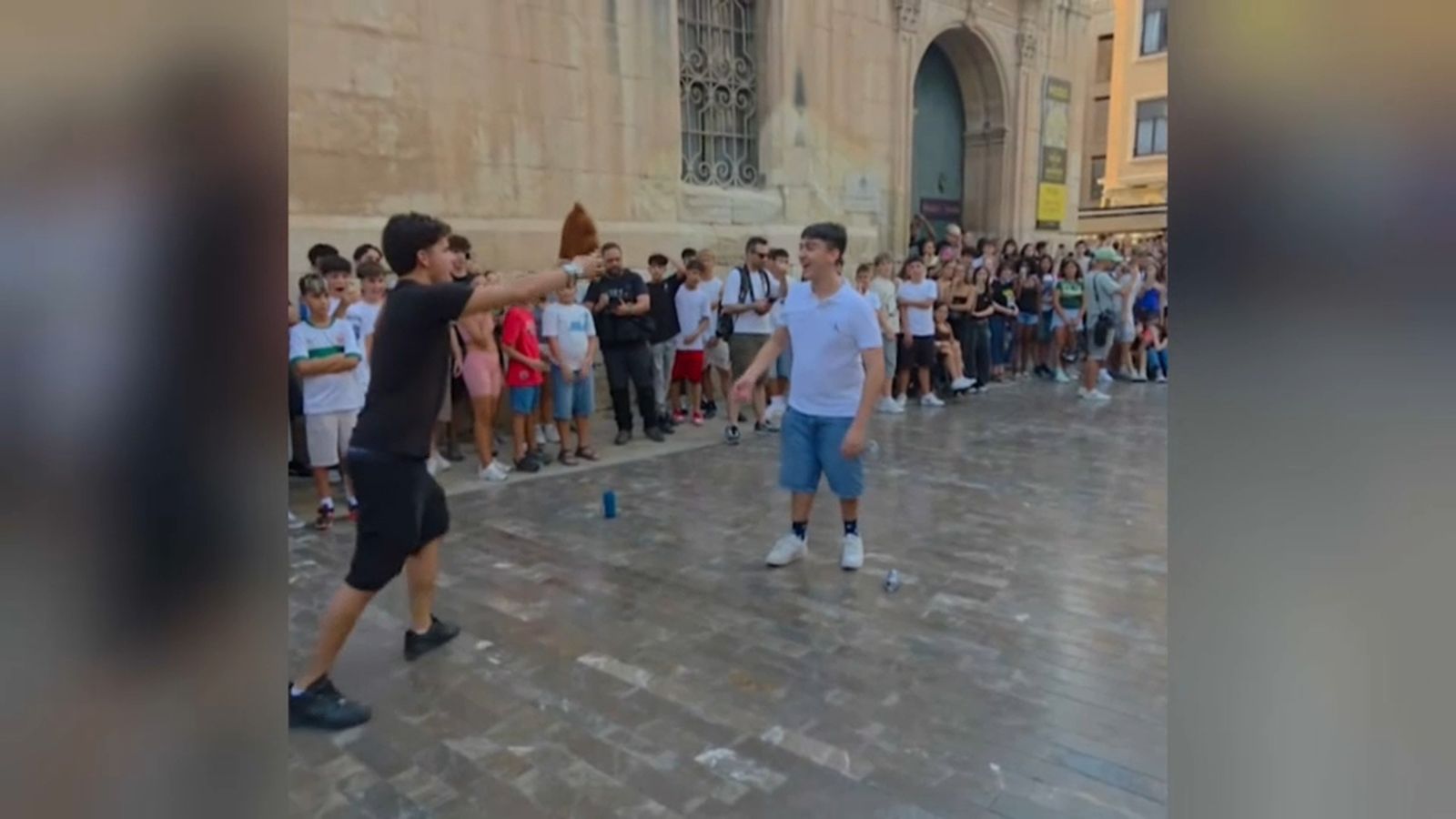 Dos adolescents als peus de la basílica de Santa Maria d'elx en l'esdeveniment per farmejar aura
