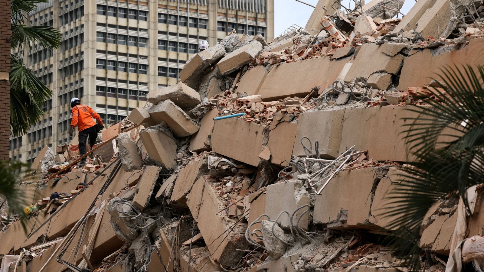 Un treballador d'un equip de rescat busca supervivents en un edifici enfonsat a Caracas, Veneçuela