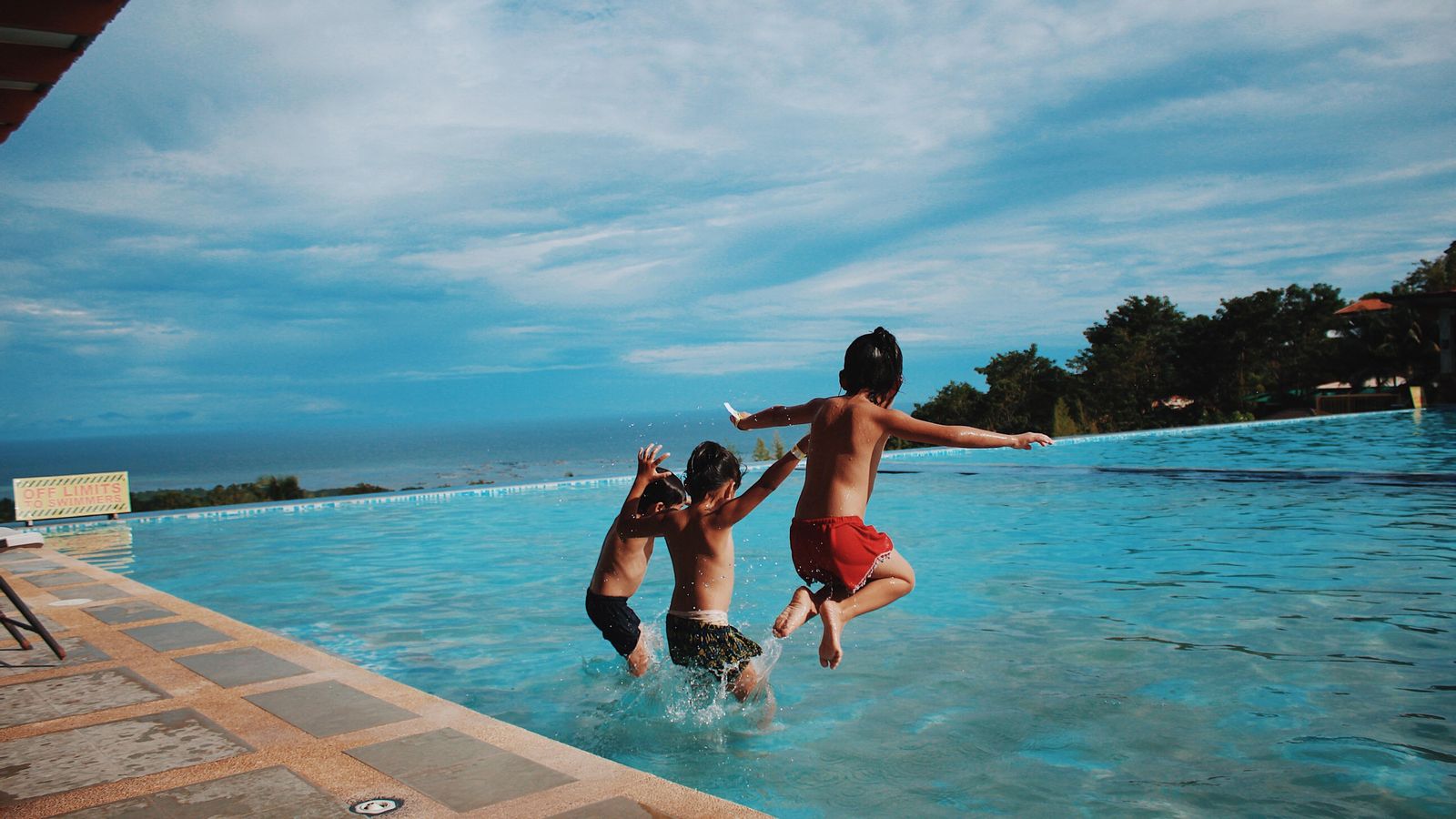 Xiquets llançant-se a la piscina en una imatge d'arxiu