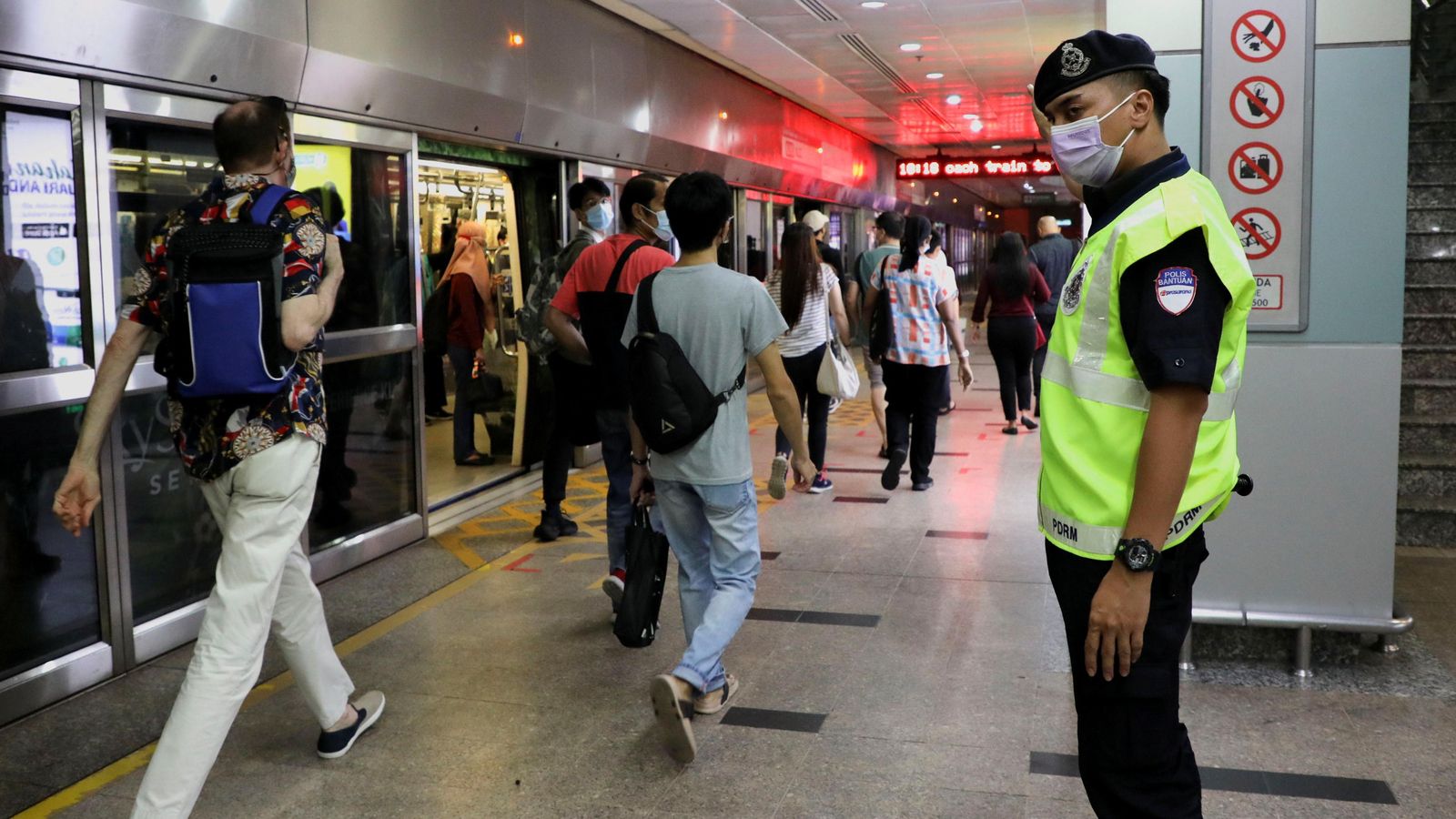Un policia guia els passatgers en l'estació on ha tingut lloc l'accident