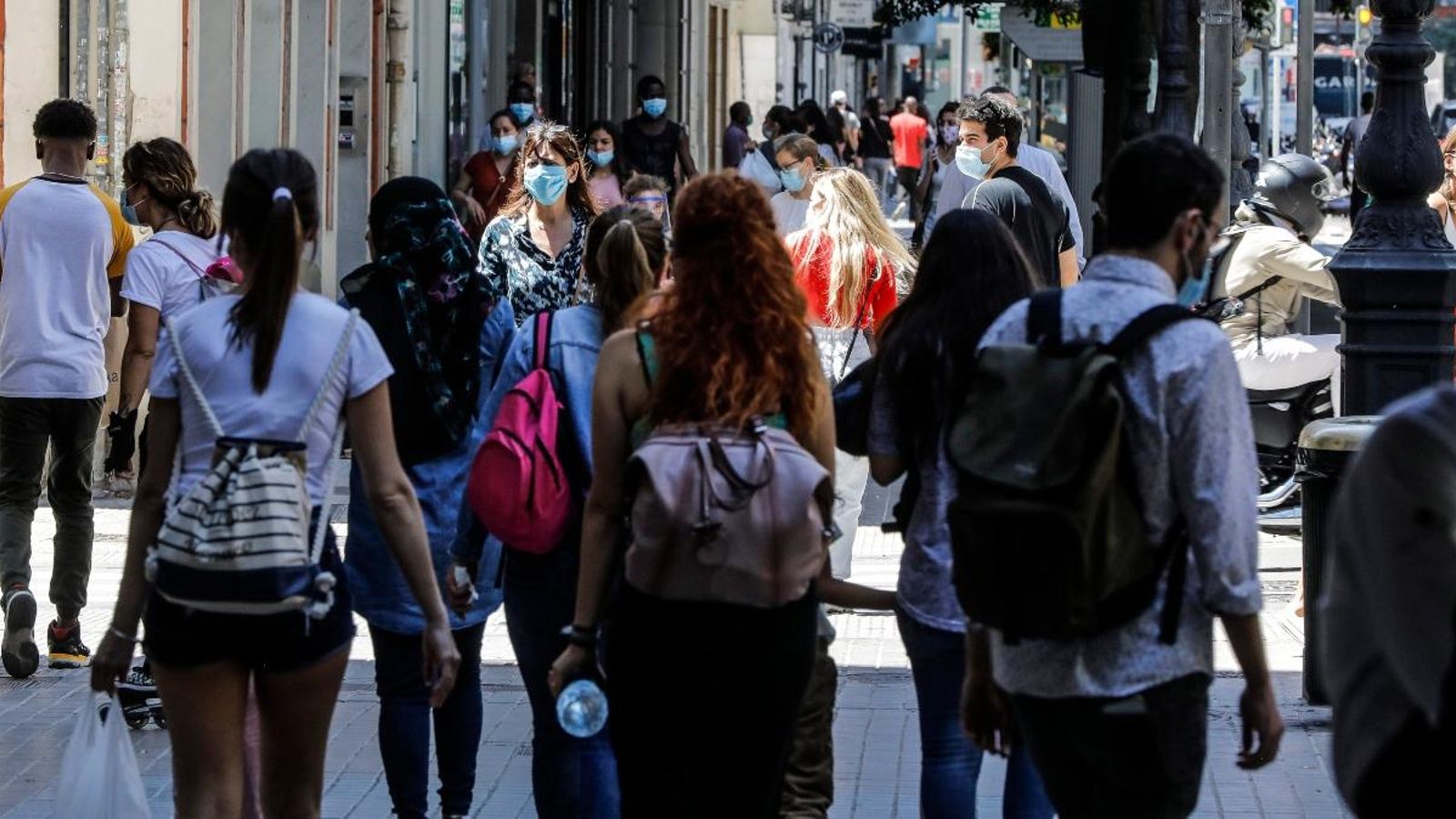 Diverses persones caminen per un carrer de València