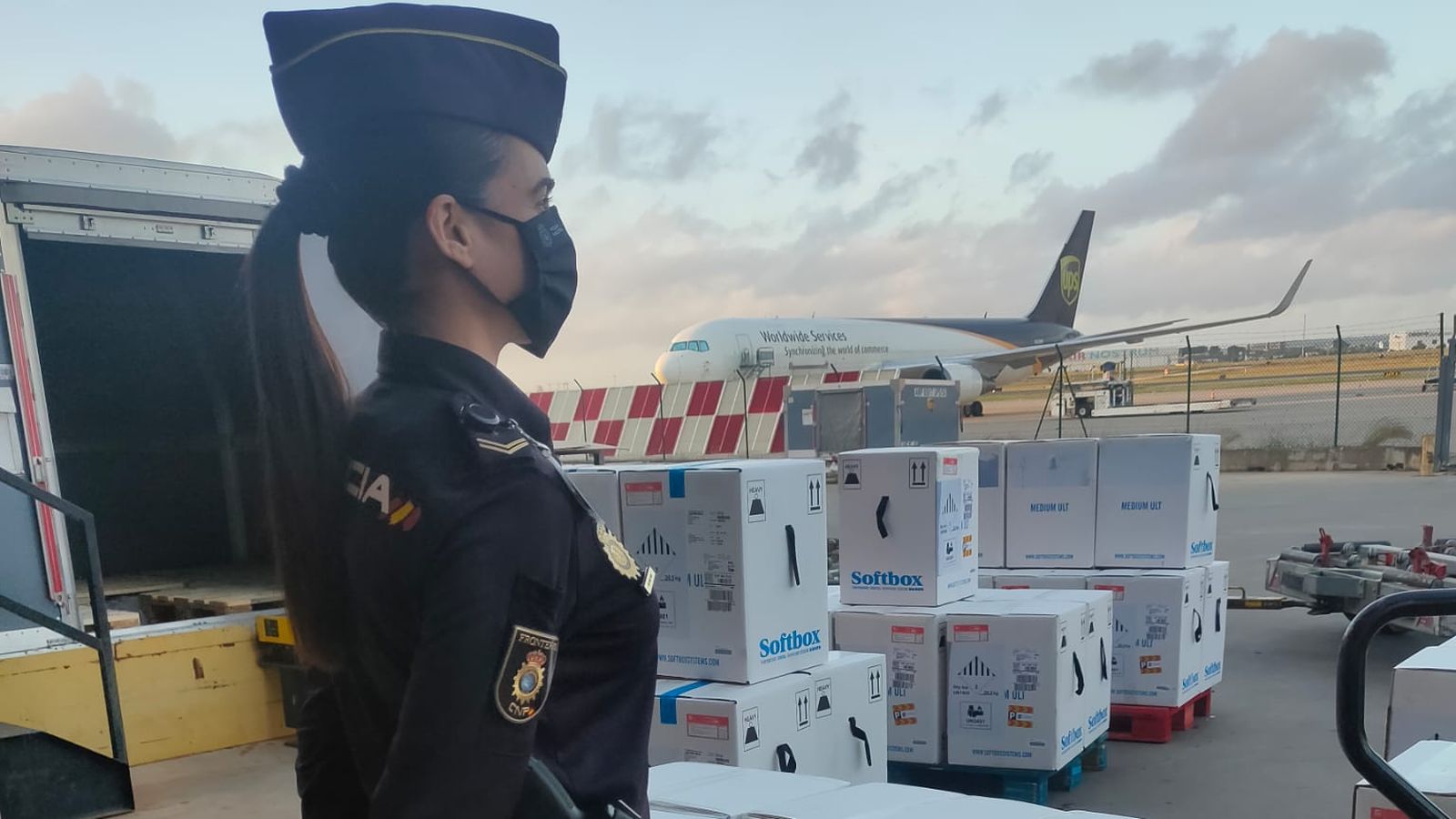 Una agent de la Policia Nacional custòdia el nou enviament de dosis Pfizer que han arribat a primera hora d'aquest dilluns a un aeroport valencià