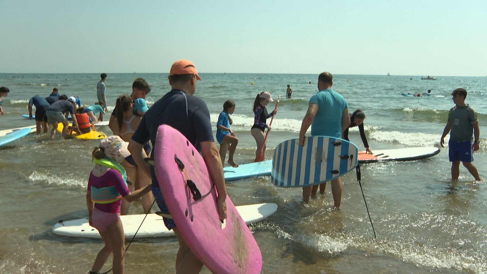Xiquets i adults participen en l'activitat de surf adaptat a la Patacona