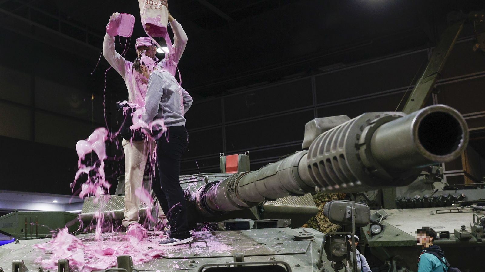 Activistes sobre un vehicle militar exposat en Expojove aquest dimarts a Fira València