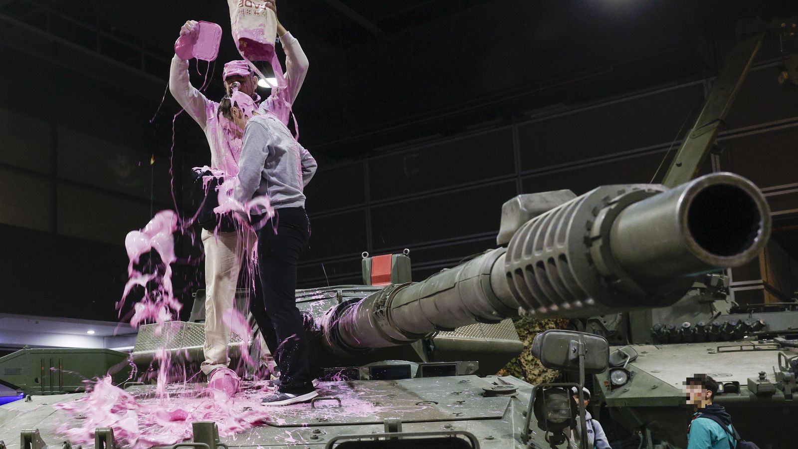 Activistes sobre un vehicle militar exposat en Expojove aquest dimarts a Fira València
