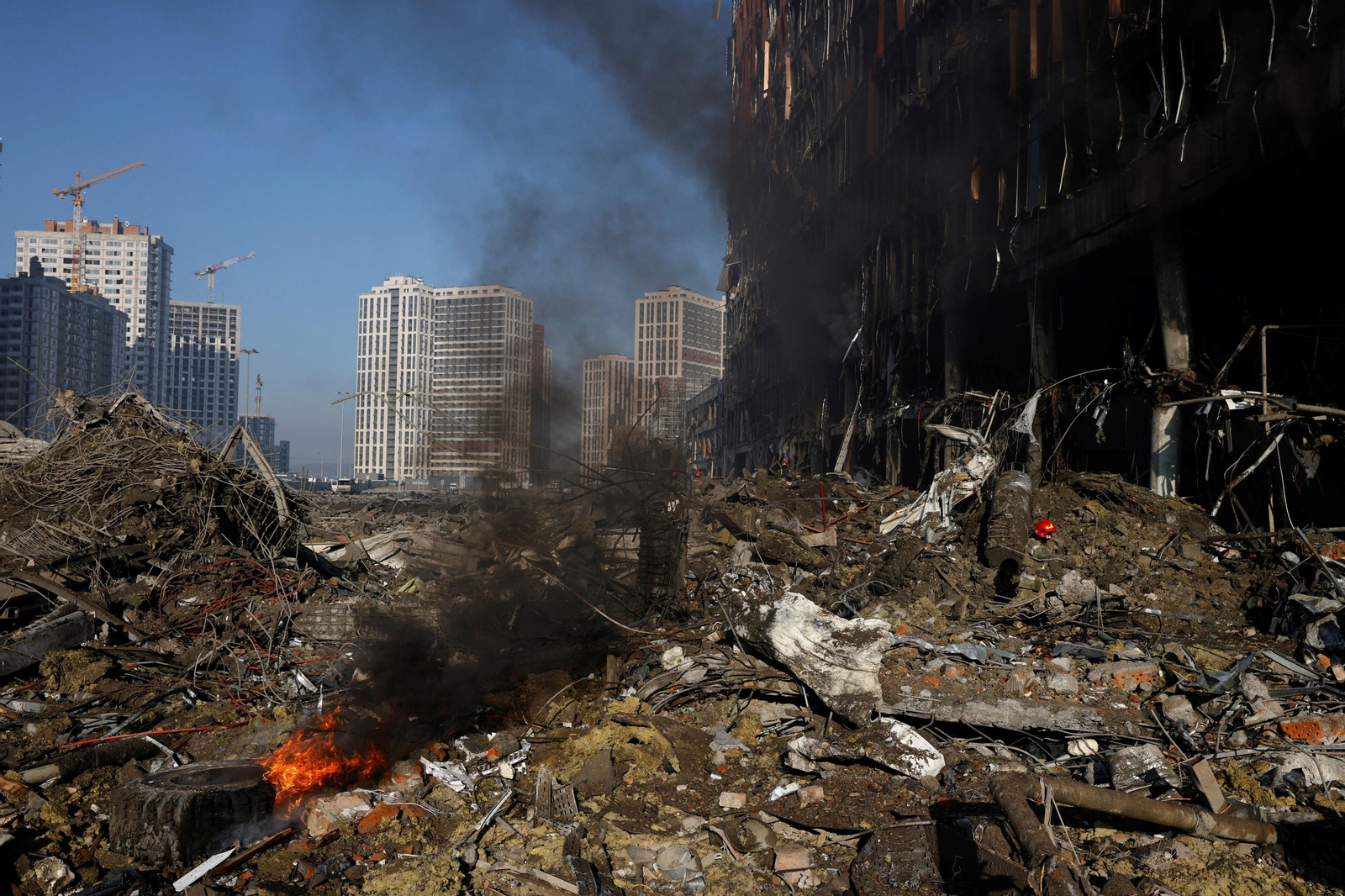 Els bombers treballen  en les runes d'un centre comercial atacat per les forces russes a Kíiv, aquest dilluns