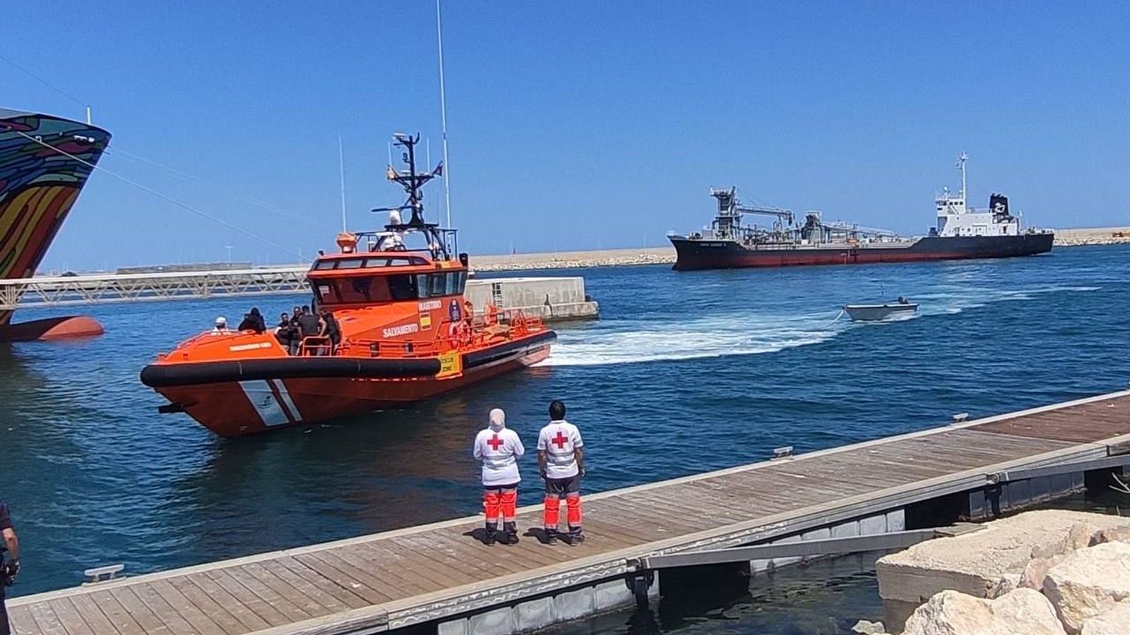 Voluntaris de Creu Roja esperen que desembarquen els migrants per a atendre'ls