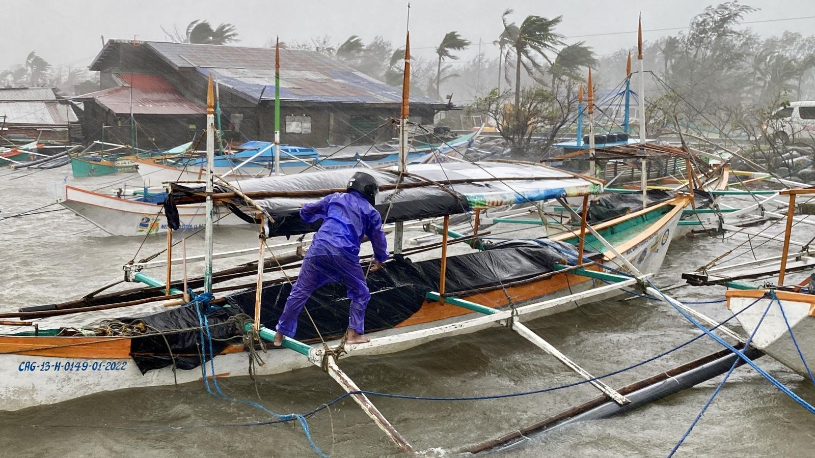 Un pescador assegura un bot durant una tempesta a Santa Ana, província de Cagayan, les Filipines Un pescador assegura un pot durant una tempesta en Santa Ana, província de Cagayan, Filipines
